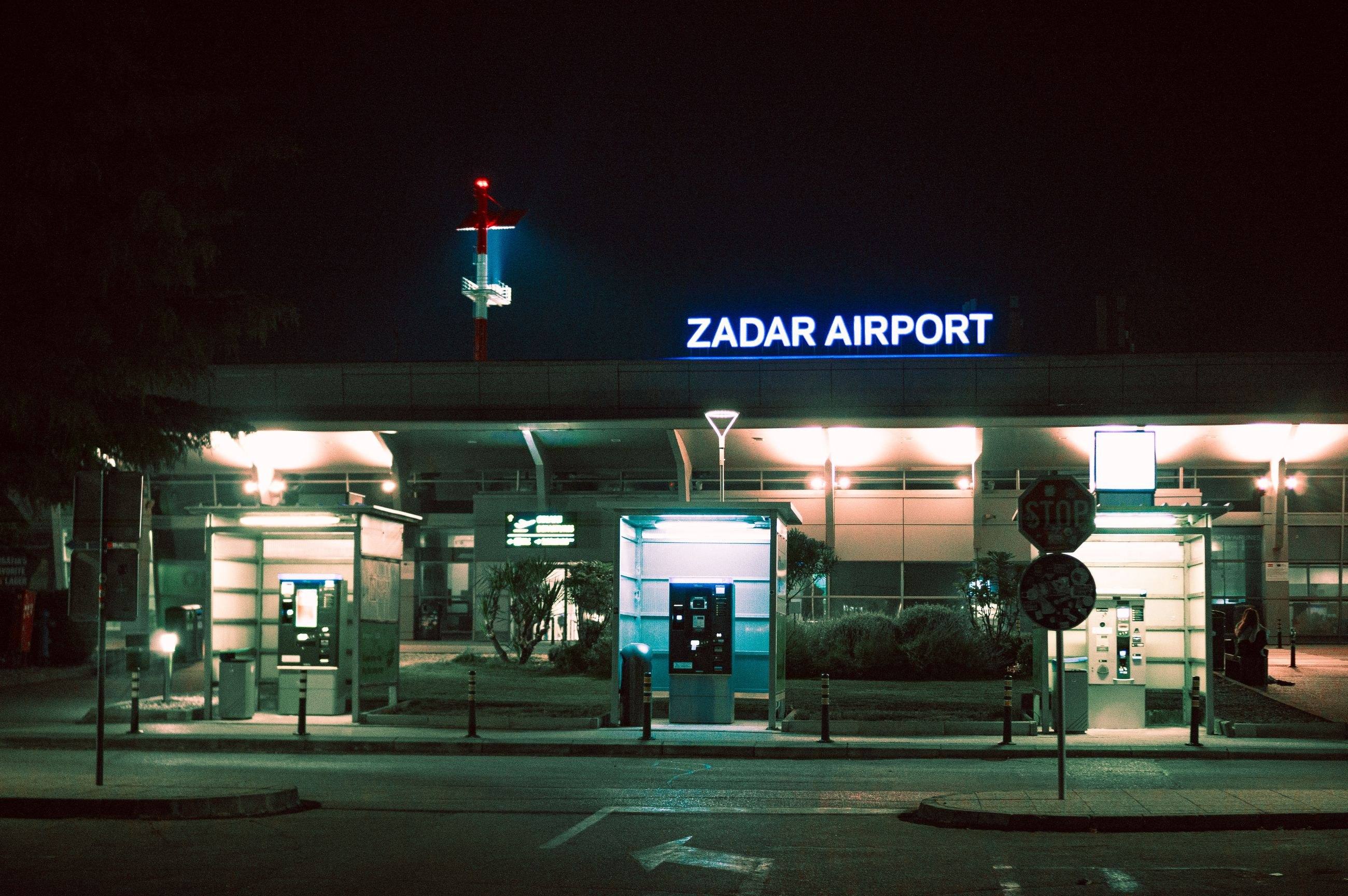 The entrance of Zadar Airport at night under its illuminated sign